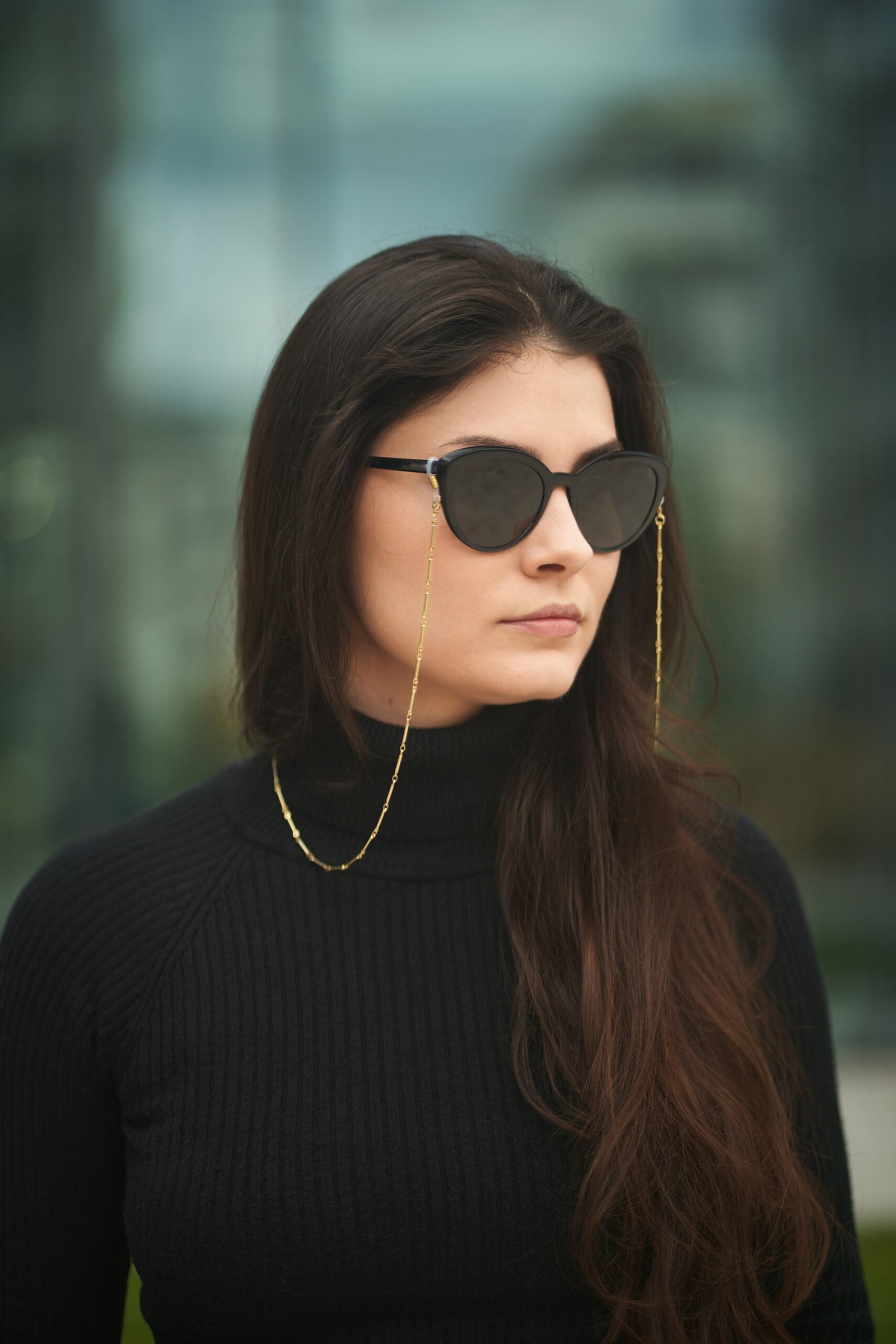 Femme portant une chaîne à lunettes dorée avec lunettes de soleil noires – Maison Lunetik